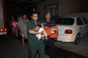  مسعف ورجل اطفاء يضعان قناع اوكسجين على وجه الطفل الرضيع بعد اخراجه من البناية 	 محمد ماهر
﻿