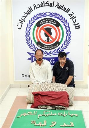 السائق الباكستاني وشريكه وامامهما كمية الهيروين المضبوطة معهما
