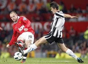 نجم مان يونايتد واين روني يمرر امام لاعب نيوكاسل جوي بارتون 	اپ﻿