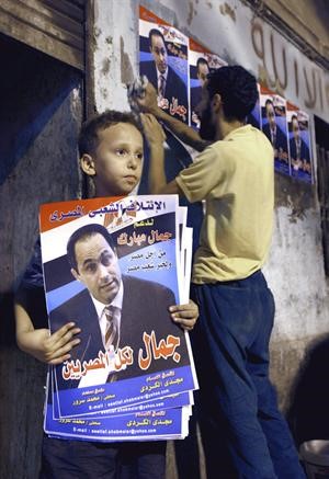 طفل مصري يحمل ملصقا دعائيا للائتلاف الشعبي المصري لدعم جمال مبارك اپ