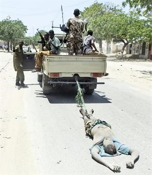 قوات الحكومة الصومالية تسحل جثة احد المسلحين منفذي الهجوم على فندق منىاپ
﻿