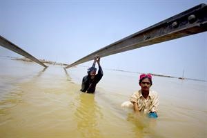 باكستانيان يستخدمان قضبان سكة حديد مدمرة لاجتياز مياه الفيضانات في جنوب باكستانرويترز - اپ
