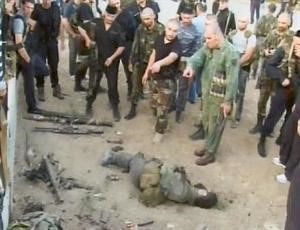 حرس الرئيس الشيشاني يعاينون جثة احد المسلحين الذين قتلوا في اشتباكات امس	 اپ﻿