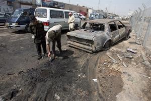عراقيون يعاينون موقع تفجير قنبلتين في وسط بغداد امس									 افپ
﻿