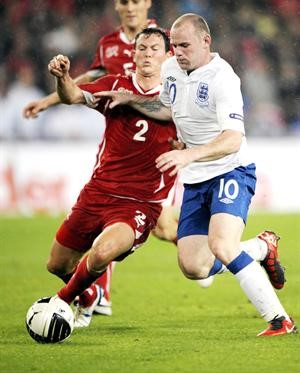 الانجليزي واين روني في صراع على الكرة مع السويسري ستيفان ليشتنشتاينر