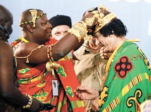 احد زعماء القبائل الافريقية مكرما الزعيم الليبي معمر القذافي في افتتاح المؤتمر الثاني لملتقى ملوك وسلاطين وامراء افريقيا بعد ان كان القذافي قد اعلن ملكا لملوك افريقيا في المؤتمر الاول اپ