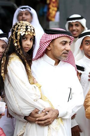 سعودي يحمل ابنته المتزينة بحلية العيد في مكة	 افپ﻿