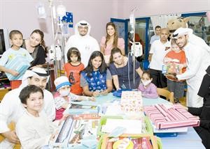 فريقا العلاقات العامة والتسويق ومتطوعو المستشفى في صورة جماعية مع الاطفال
﻿