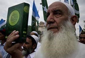 احد مؤيدي حزب جماعة الاسلامي الديني الباكستاني يمسك بنسخة من القران الكريم اثناء مظاهرة تندد بخطط حرق المصحف الشريف