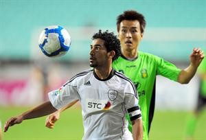 لاعب الشباب احمد عطيف يسيطر على الكرة بمراقبة لاعب شونبوك لي دونغ كووك 	افپ﻿