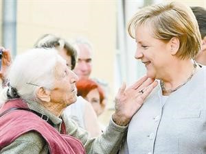 السيدة العجوز اريكا تلامس وجه المستشارة الالمانية انجيلا ميركل ﻿