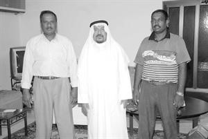 مرتضى الخباز متوسطا اثنين من العاملين لديه