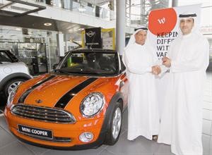 عبدالرزاق عيسى اللطيف الفائز بسيارة ميني كوبر يتسلم الجائزة من عبدالعزيز البالول﻿