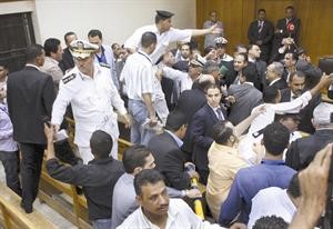 رجال الامن ينظمون قاعة المحكمة بعد الفوضى التي عمتها بعد صدور الحكم