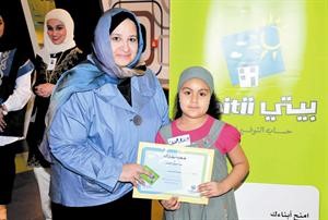 هالة التناك تسلم الشهادة لطفلة مشاركة
