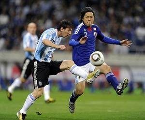 نجم الارجنتين ليونيل ميسي يسيطر على الكرة بمراقبة الياباني ياسوهيتو ايندو افپ