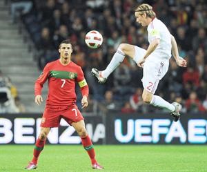 النجم البرتغالي كريستيانو رونالدو يتابع محاولة الدنماركي كريستيان بولسن السيطرة على الكرة﻿