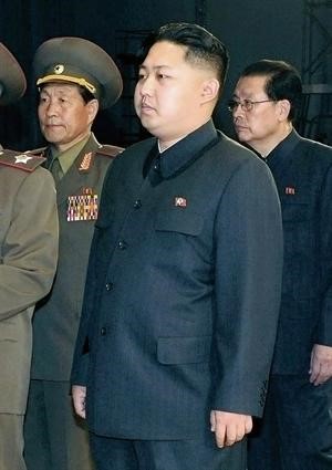 كيم يونغ اون نجل الزعيم الكوري الشمالي متطلعا الى والده خلال زيارته المسرح القومي في العاصمة