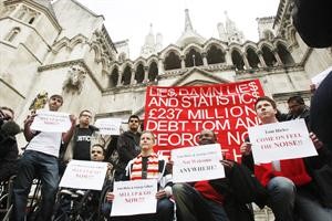 مشجعون لليفربول يرفعون لافتة كتبت عليها عبارات التنديد بالمالكين الاميركيين امام المحكمة الملكية العليا في لندن 	اپ﻿