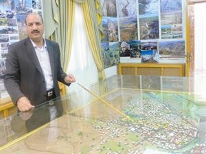مدير العالاقات العامة في محافظة القنيطرة محمد علي مشيرا الى مجسم لاراضي الجولان المحتلة