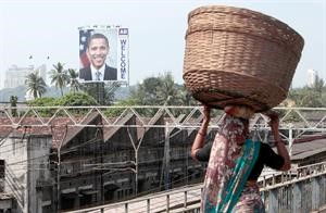 مواطنة هندية تمر على احد الجسور بالهند وتبدو صورة ترحيبية بالرئيس الاميركي باراك اوباما
﻿