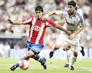 نجم اتلتيكو مدريد سيرجيو اغويرو يمر بالكرة من مدافع ريال مدريد سيرجيو راموس في مباراة سابقة﻿