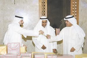 الهاجري يسلم احد الكوبونات الفائزة للزميل عدنان الراشد بمتابعة من خالد السلطان﻿