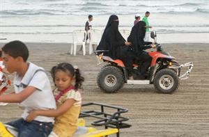 فتاة يمنية تقود البانشي وخلفها امراة مسنة في احد شواطئ اليمن قبل ايام من انطلاق خليجي 20	الازرقكوم﻿