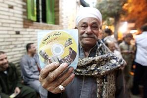 مواطن مصري يحمل قرصا مدمجا يحوي معلومات دعائية عن احد مرشحي جماعة الاخوان المسلمين	 افپ﻿