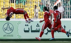 المهاجم العماني عماد الحوسني طائرا في الهواء احتفالا بهدفه في البحرين	افپ﻿