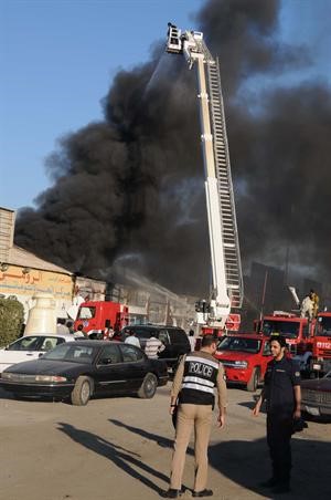 السنة الدخان تغطي محيط الفحيحيل الصناعية ويبدو رجال اطفاء يتعاملون مع الحريق﻿