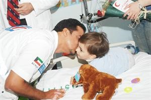 احد متطوعي الهلال الاحمر خلال زيارة احد الاطفال
