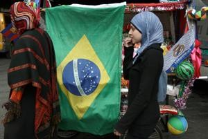 فلسطينيتان تمران امام العلم البرازيلي في احد اسواق رام الله امس 	افپ﻿