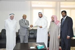 دعبدالله المعتوق والمشير سوار الذهب يتبادلان وثائق الاتفاق بحضور امين سر الهيئة عبدالرحمن بن عقل والمدير العام د شمس الدين
