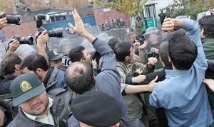 صحافيون يحاولون التقاط صورة لاعضاء من الباسيج تظاهروا امام السفارة البريطانية في طهران امس	افپ﻿