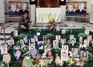 عراقي مسلم يقرا الفاتحة عند صور ضحايا كنيسة سيدة النجاة في بغداد في اطار احياء اعياد الميلاد 	اپ﻿