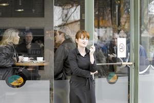 اسبانية تدخن خارج المطعم بعد تطبيق قانون حظر التدخين﻿
