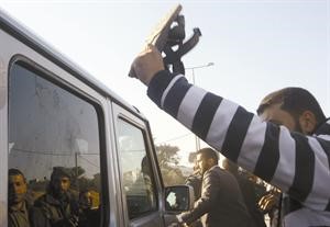 احد المتظاهرين يرفع حذاءه معترضا موكب وزيرة الخارجية الفرنسية ميشال اليوماري	افپ﻿
