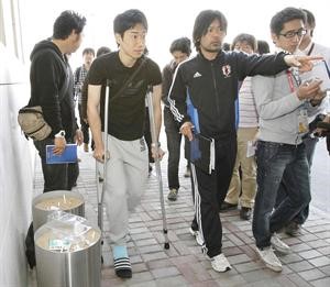 الياباني شينجي كاغاوا يسير على عكازين في مطار الدوحة قبل مغادرته امس	رويترز
﻿