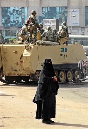  وسيدة مصرية تعبر بجانب احدى اليات الجيش	افپ﻿