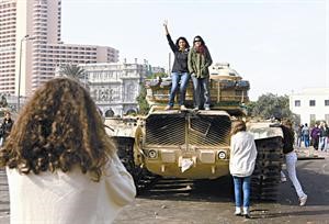 فتيات يلتقطن صورا تذكارية من على دبابة وسط القاهرة