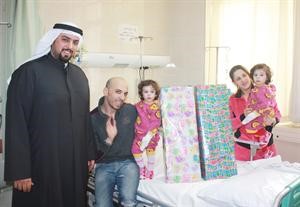 جانب من الزيارة ويبدو القناعي اثناء تقديم الهدايا للاطفال

