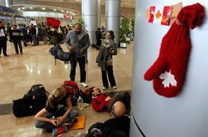 سياح كنديون ينتظرون دورهم للمغادرة من مطار القاهرة	اپ﻿