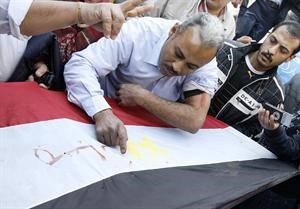 احد مؤيدي الرئيس المصري يكتب اسمه بالدم على العلم وسط القاهرة امس	 افپ﻿