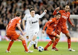 الالماني مسعود اوزيل نجم ريال مدريد يحاول المرور بين لاعبي اشبيلية 	افپ
﻿