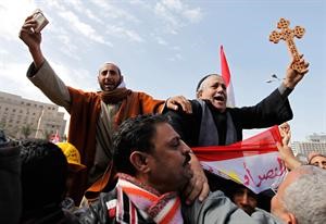 مسيحي يحمل صليبا ومسلم يحمل مصحفا جنبا الى جنب في مظاهرات ميدان التحرير التي استمرت امس	رويترز﻿