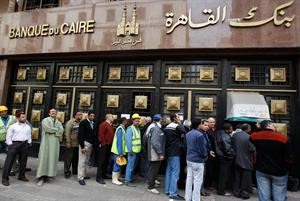 عشرات المصريين يصطفون امام احد البنوك بعد عودتها للعمل اثر اغلاق دام اسبوعا﻿
