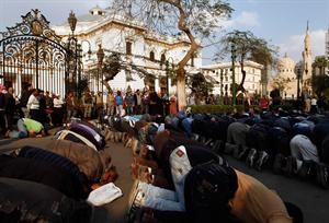 عشرات المحتجين يؤدون الصلاة خلال اعتصامهم امام مجلس الشعب وسط القاهرة امس	رويترز﻿