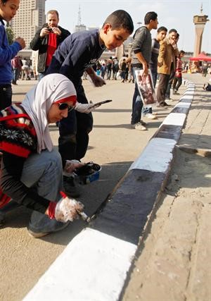 شباب مصريون يدهنون الارصفة بعد انفضاض الاحتجاجات	اپ﻿