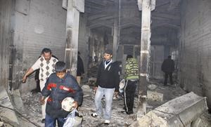  ومدنيون ليبيون يعاينون احد الابنية المدمرة جراء الاشتباكات في بنغازي	اپ﻿
